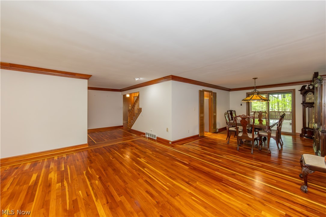 25001 Letchworth Road Beachwood, OH 44122 - Photo 4 of 50 Spacious interior featuring hardwood flooring with contrasting border, wood trim and crown molding, and a staircase with wood railings