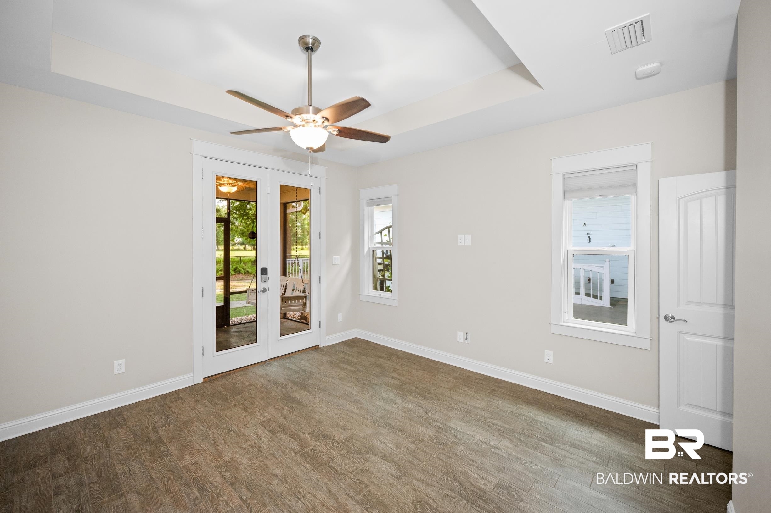 12254 Reunion Place Foley, AL 36535 - Photo 26 of 62 Unfurnished room featuring a raised ceiling, french doors, a ceiling fan, wood finished floors, and baseboards