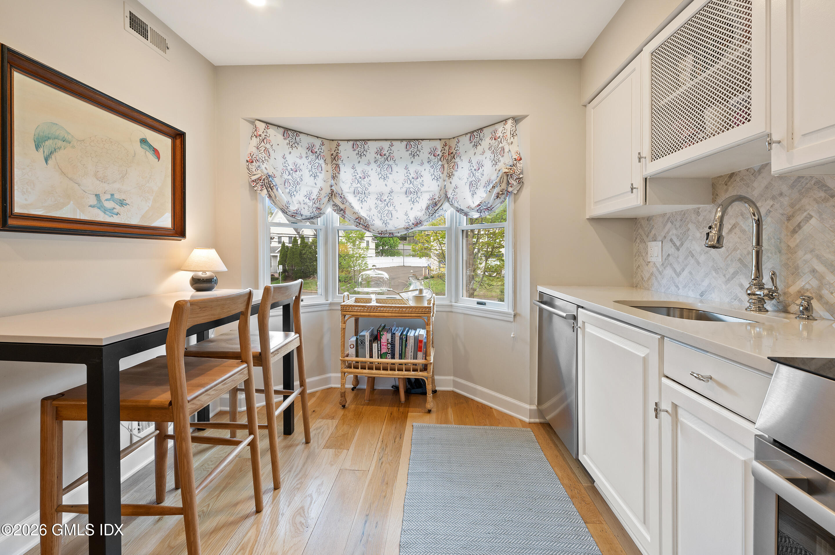 115 River Road, Unit 3 Cos Cob, CT 06807 - Photo 12 of 40 a kitchen with stainless steel appliances a table and chairs in it
