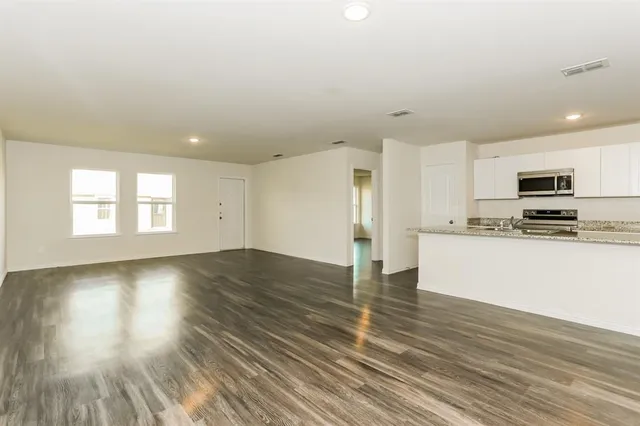 a view of kitchen with granite countertop stainless steel appliances refrigerator sink and microwave