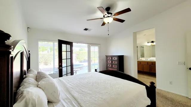 a bedroom with a large bed and a chandelier