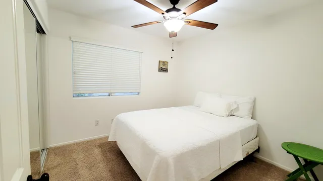a bedroom with a large bed and a chandelier