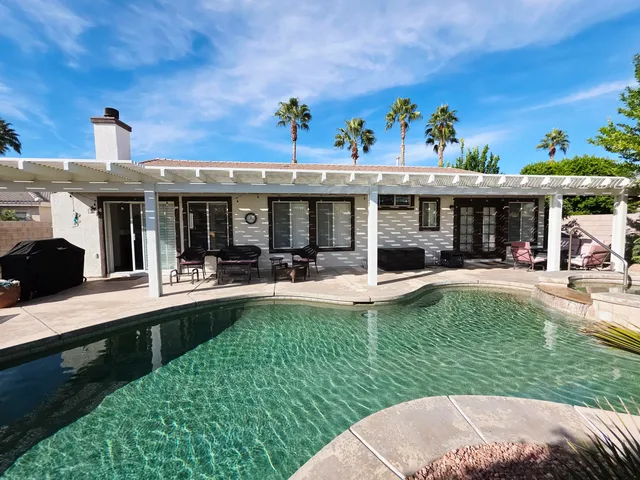 a front view of a house with swimming pool outdoor seating