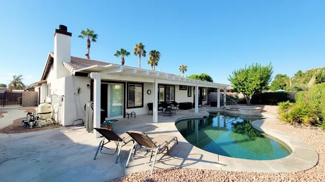 a view of a house with backyard water fountain and sitting area