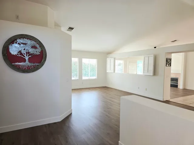 an empty room with wooden floor and a window