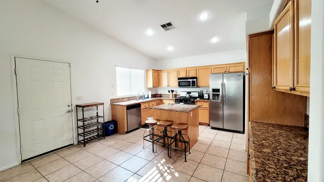 a kitchen with a refrigerator a counter top space and cabinets