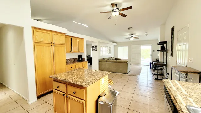 a kitchen with stainless steel appliances granite countertop a refrigerator a oven a sink dishwasher and white cabinets with wooden floor