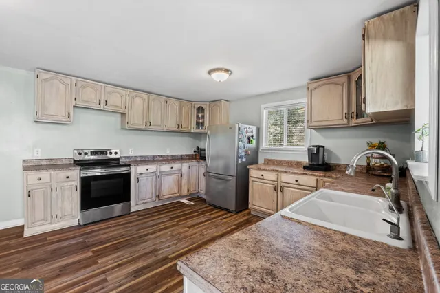 a kitchen with granite countertop a sink cabinets stainless steel appliances and a counter space