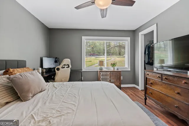 a bedroom with a large bed and a flat tv screen on dresser
