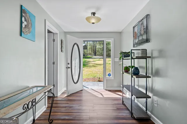 a view of a hallway with wooden floor and entryway