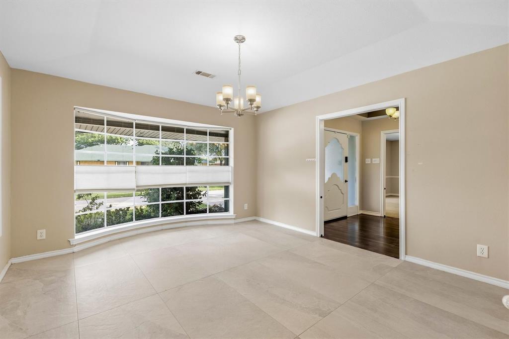 4436 Thunder Road Dallas, TX 75244 - Photo 6 of 33 Recessed ceiling with a chandelier, bay window, light-toned tile flooring, and a decorative interior door