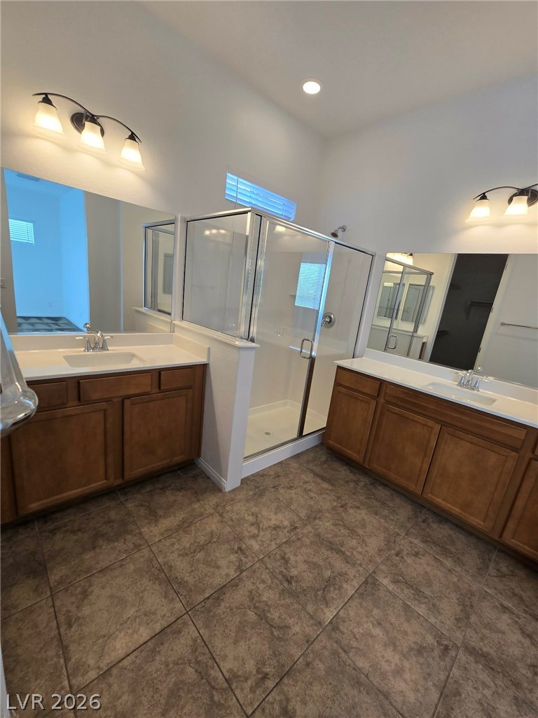 4748 Ritual Street North Las Vegas, NV 89031 - Photo 13 of 31 Dual vanities and a glass-enclosed shower create a practical, functional bathroom.