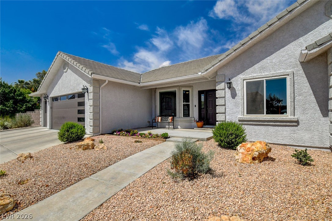 4362 Thistle Street Logandale, NV 89021 - Photo 5 of 99 A welcoming front entrance with a clean, low-maintenance gravel landscape and integrated garage.