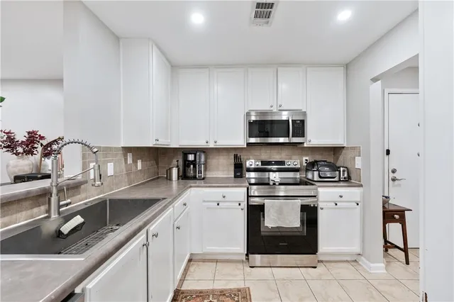 a kitchen with stainless steel appliances granite countertop a sink and a stove