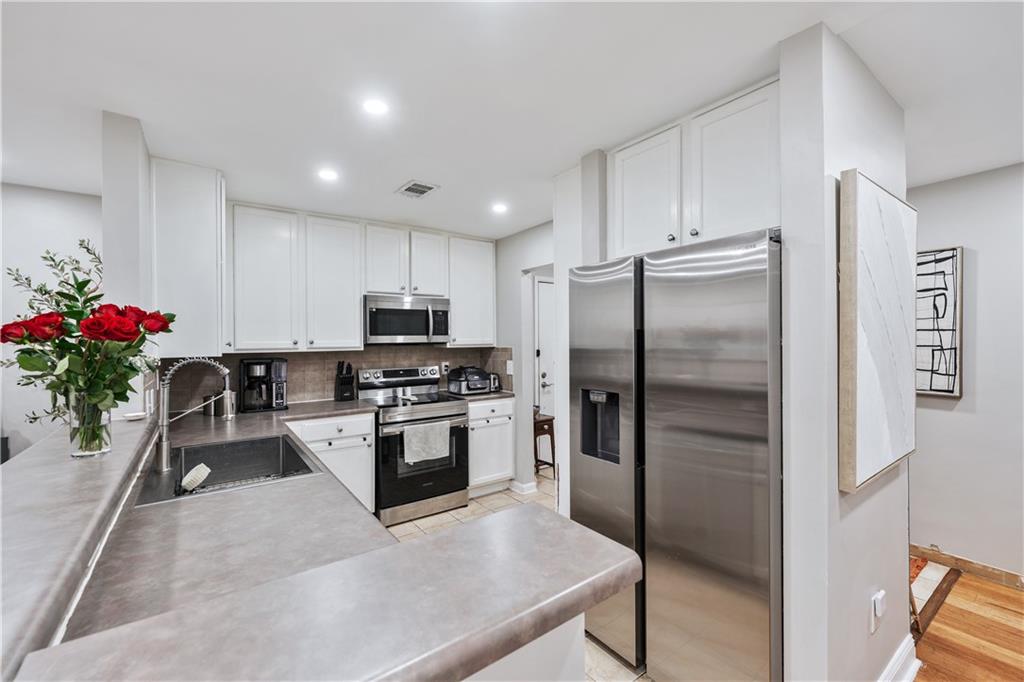 3650 Ashford Dunwoody Road Northeast, Unit 1026 Atlanta, GA 30319 - Photo 13 of 28 a kitchen with granite countertop a refrigerator and stainless steel appliances