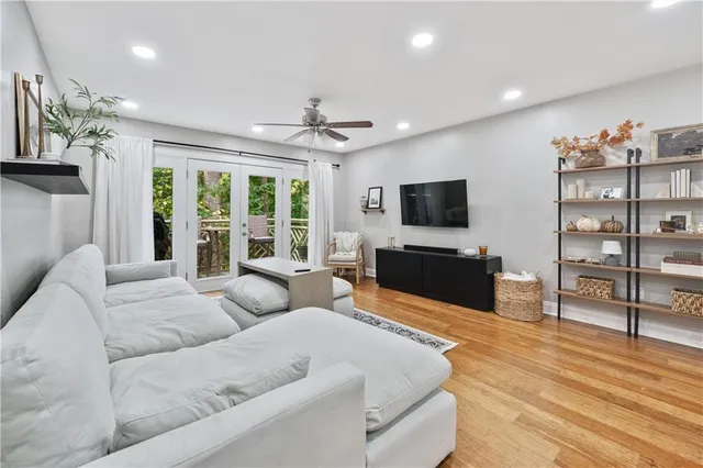 a living room with furniture a flat screen tv and a floor to ceiling window