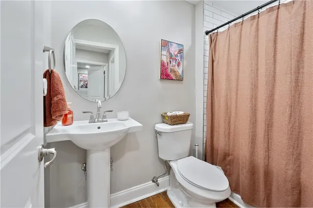 a bathroom with a toilet sink and mirror