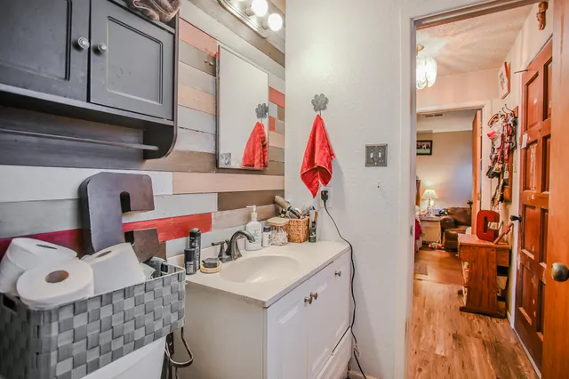 a bathroom with a sink and mirror with bathtub