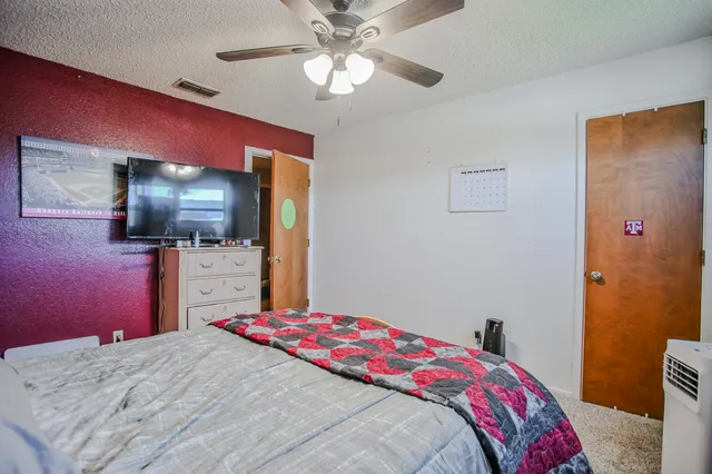 a bedroom with a bed and a flat screen tv