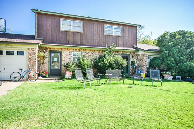 a view of a house with backyard and sitting area