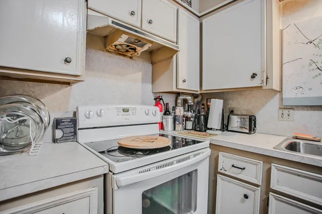 a kitchen with a stove and a white cabinets