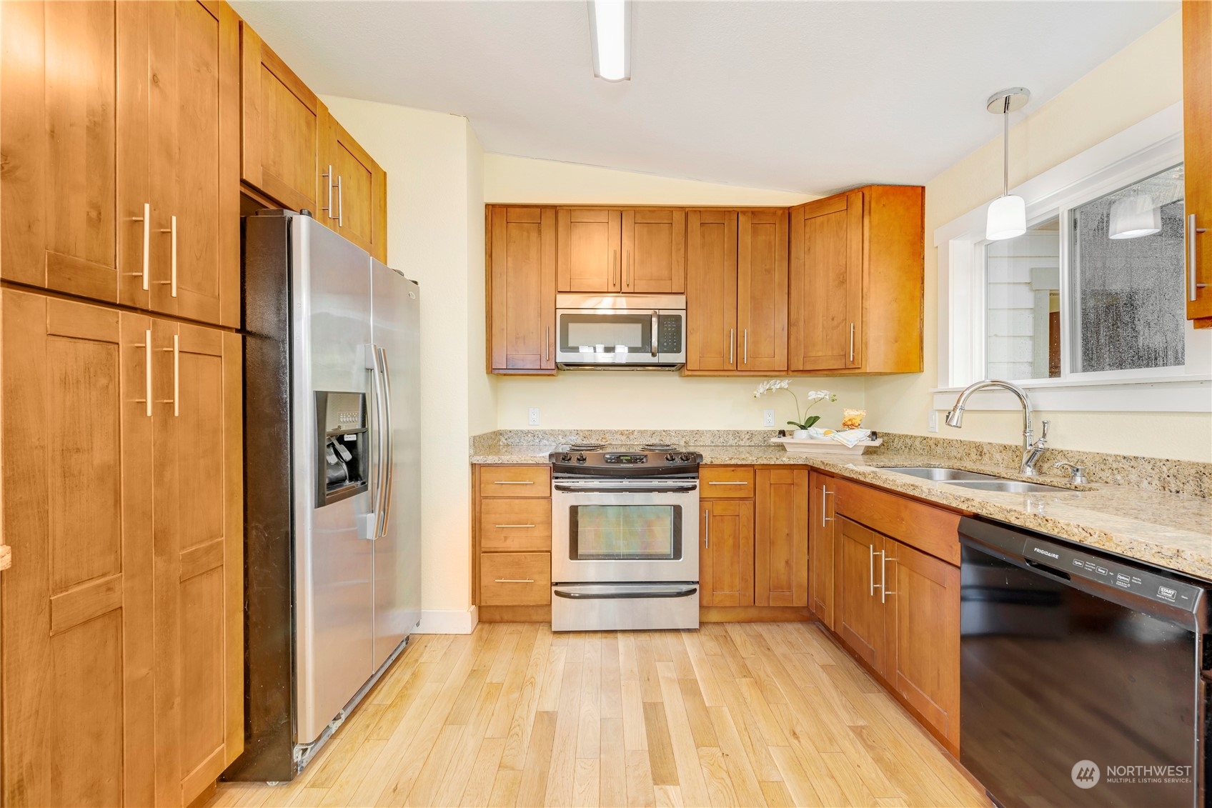 11404 Southeast 169th Street Renton, WA 98055 - Photo 7 of 25 a kitchen with stainless steel appliances granite countertop a stove a sink dishwasher and a refrigerator