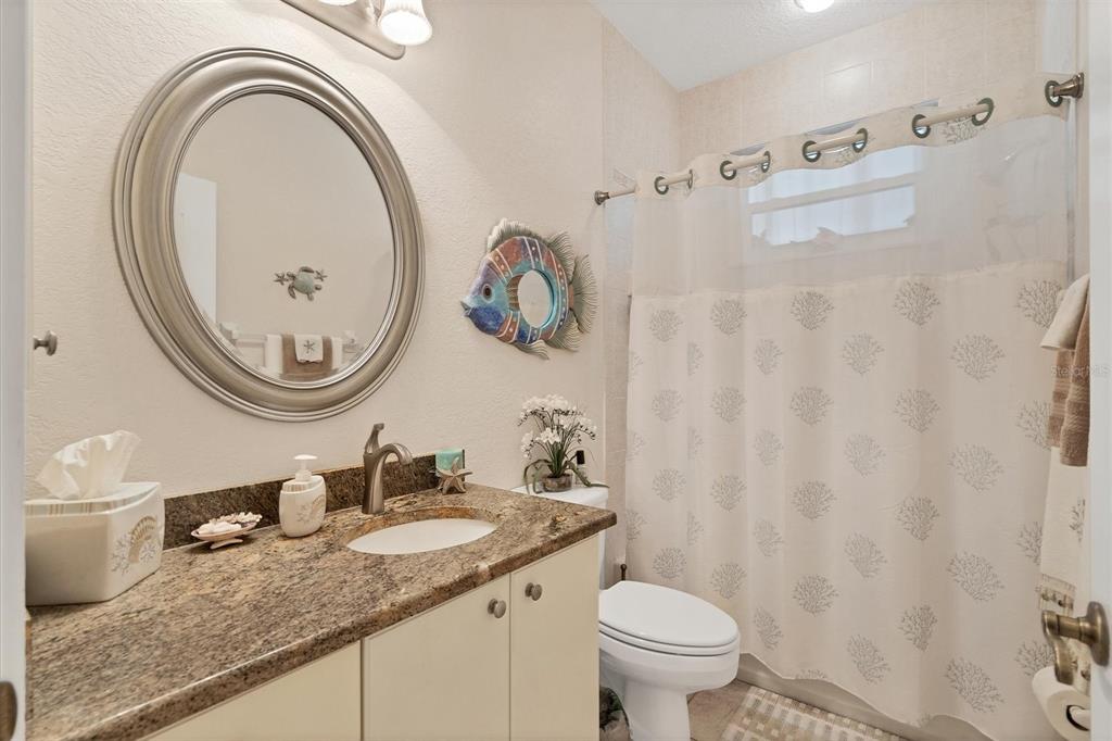 200 Capstan Drive Placida, FL 33946 - Photo 30 of 86 a bathroom with a granite countertop toilet a sink and a mirror