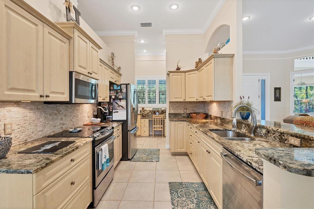 200 Capstan Drive Placida, FL 33946 - Photo 9 of 86 a kitchen with stainless steel appliances granite countertop a stove top oven a sink a refrigerator and white cabinets with wooden floor