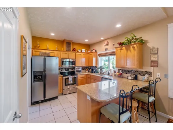 a kitchen with refrigerator and chairs