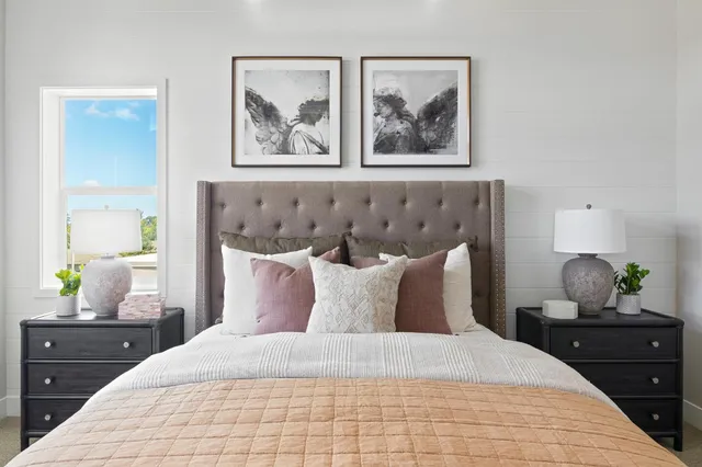 a bedroom with a bed and lamp on dresser