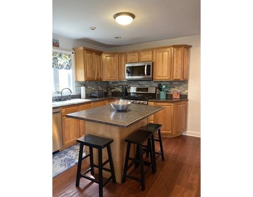 103 Chicago Street Fall River, MA 02721 - Photo 4 of 39 a kitchen with stainless steel appliances a table and chairs in it