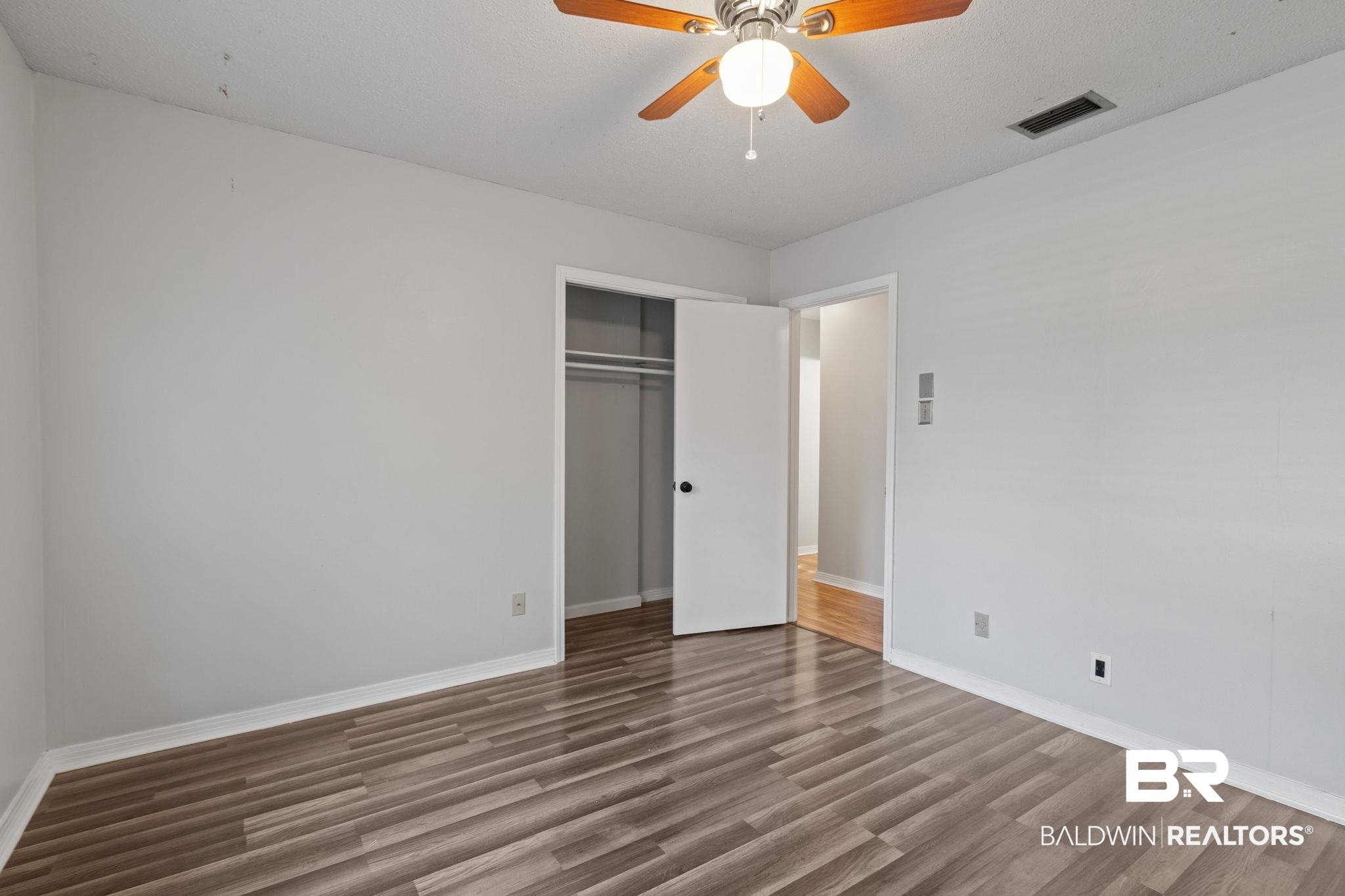 3864 Leroy Stevens Road Mobile, AL 36619 - Photo 24 of 33 Unfurnished bedroom with dark wood finished floors, a closet, and ceiling fan