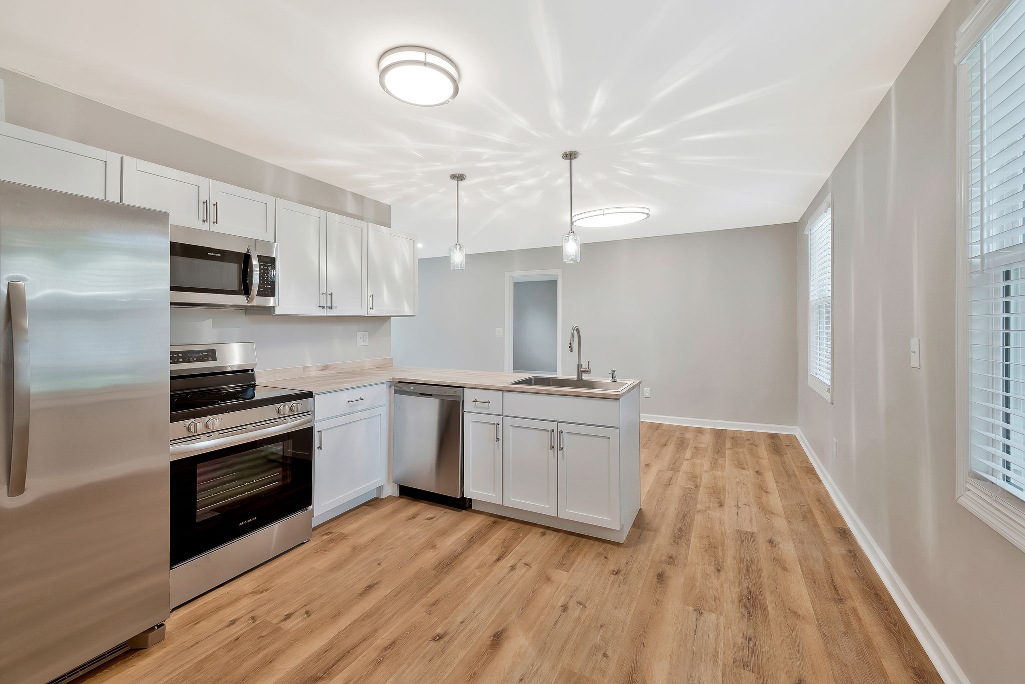 213 Manzano Road Madison, TN 37115 - Photo 5 of 24 a kitchen with cabinets wooden floor and stainless steel appliances