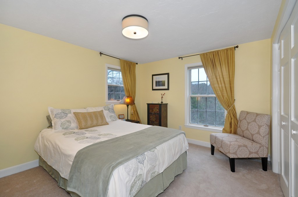 23 Wright Farm, Unit 23 Concord, MA 01742 - Photo 23 of 30 a bedroom with a bed and a couch