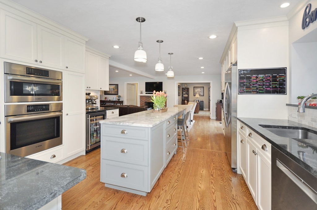 23 Wright Farm, Unit 23 Concord, MA 01742 - Photo 9 of 30 a large kitchen with stainless steel appliances kitchen island granite countertop a large stove a sink dishwasher and white cabinets with wooden floor