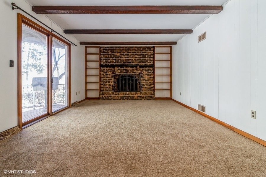 195 Ridge Avenue Crystal Lake, IL 60014 - Photo 4 of 15 a view of an empty room with a fireplace and a window