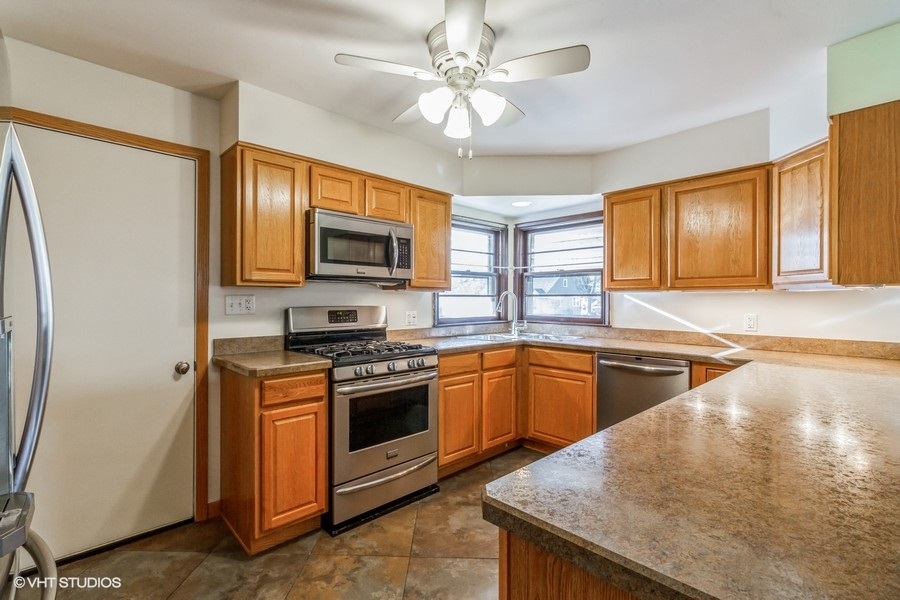 195 Ridge Avenue Crystal Lake, IL 60014 - Photo 8 of 15 a kitchen with stainless steel appliances granite countertop a stove a sink and a refrigerator