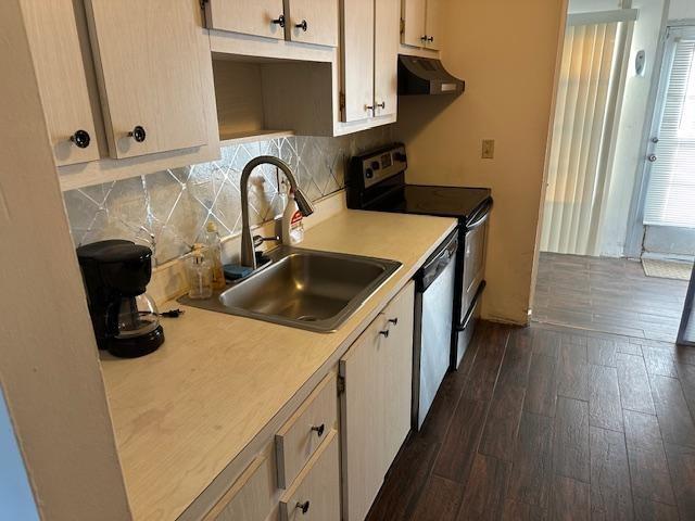a kitchen with a sink and a stove top oven with wooden floor