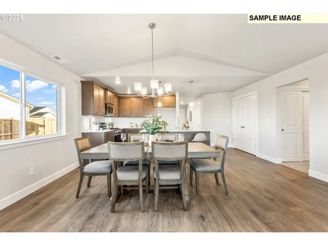 a dining room with furniture a chandelier and wooden floor