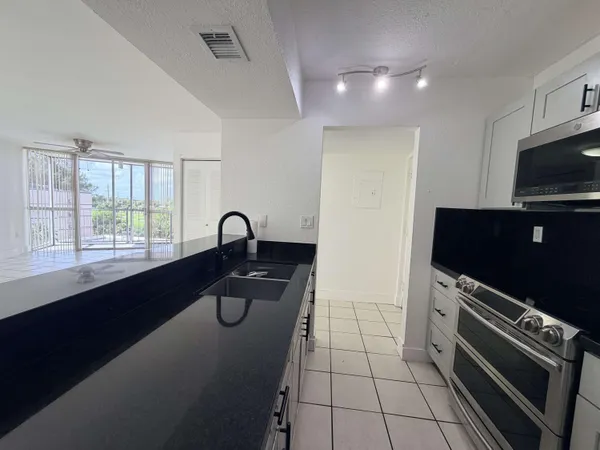 a kitchen with a sink a counter and appliances
