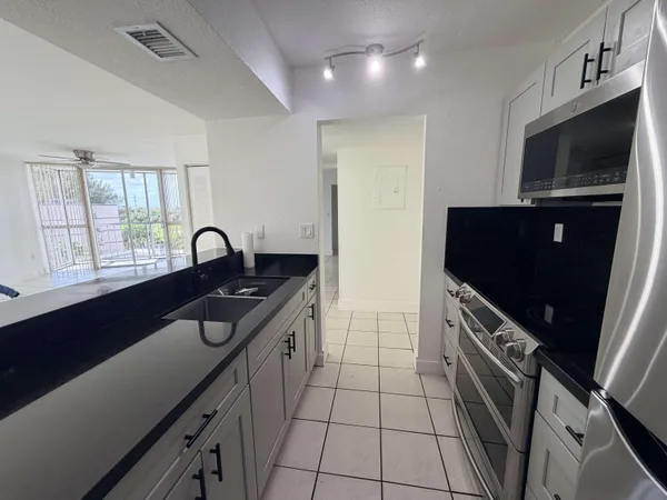 a kitchen with a sink a stove and cabinets