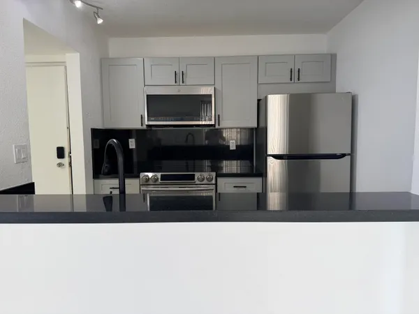 a kitchen with stainless steel appliances a refrigerator a stove a microwave and cabinets