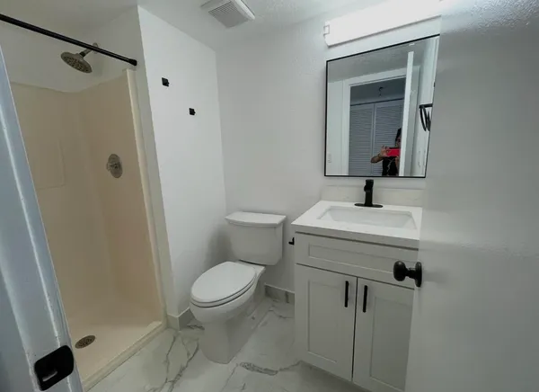 a bathroom with a toilet sink and shower