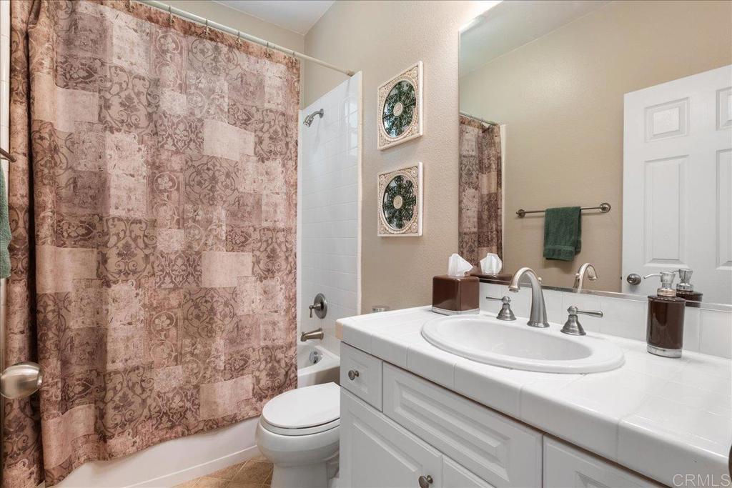 2667 Fallsview Road San Marcos, CA 92078 - Photo 30 of 54 a bathroom with a granite countertop sink a toilet and a mirror