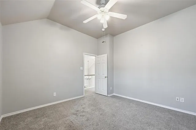an empty room with a chandelier fan and closet area