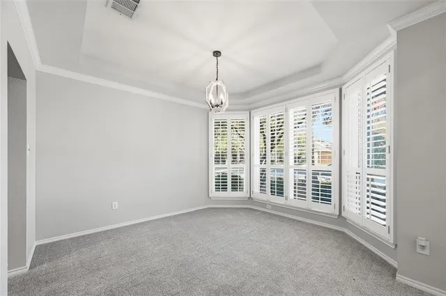 an empty room with windows and chandelier