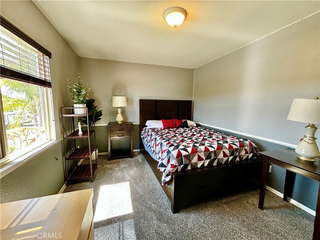 1005 Garrett Way San Jacinto, CA 92583 - Photo 20 of 29 a bedroom with a bed and dresser next to a window