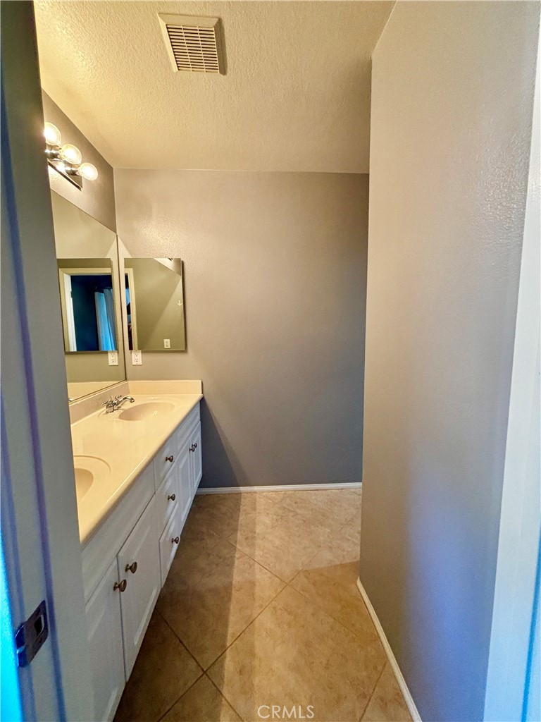 1005 Garrett Way San Jacinto, CA 92583 - Photo 21 of 29 a bathroom with a sink and a mirror