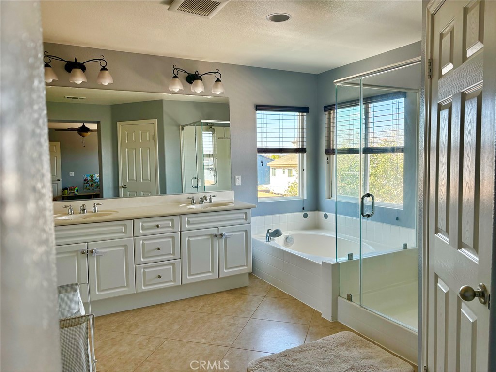 1005 Garrett Way San Jacinto, CA 92583 - Photo 27 of 29 a spacious bathroom with a tub sink and mirror