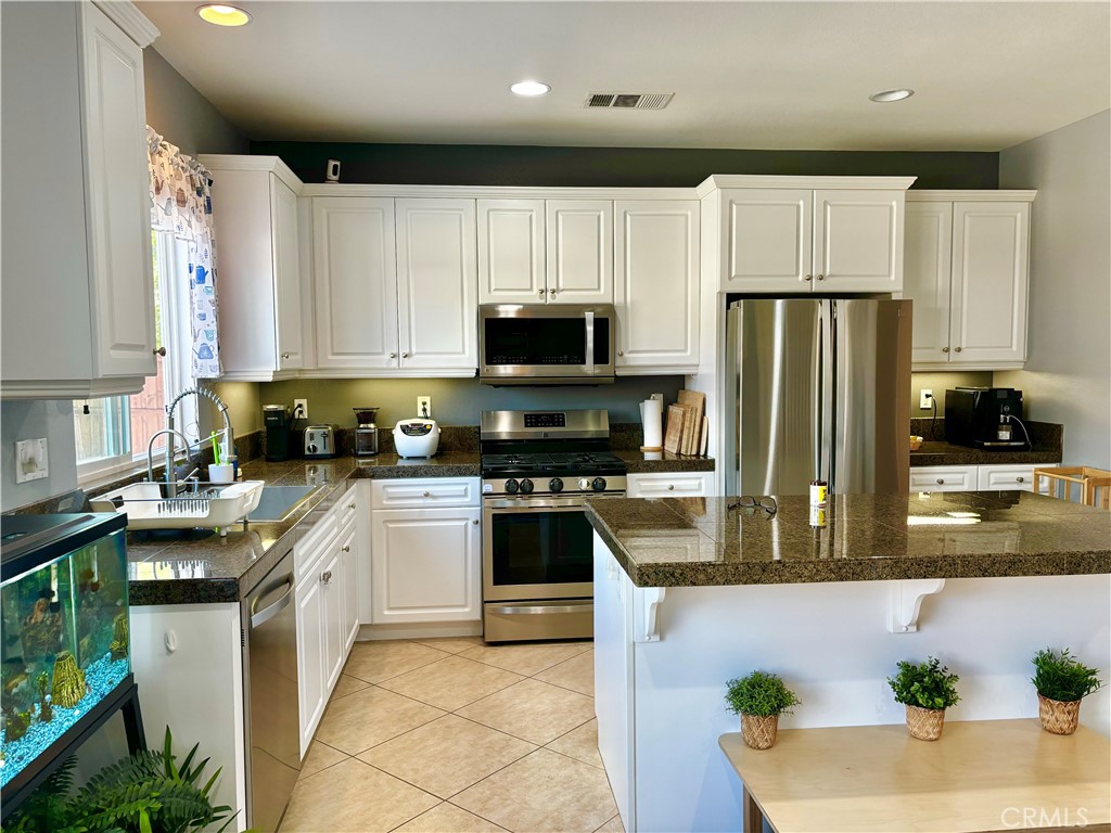 1005 Garrett Way San Jacinto, CA 92583 - Photo 8 of 29 a kitchen with granite countertop a refrigerator and a stove top oven